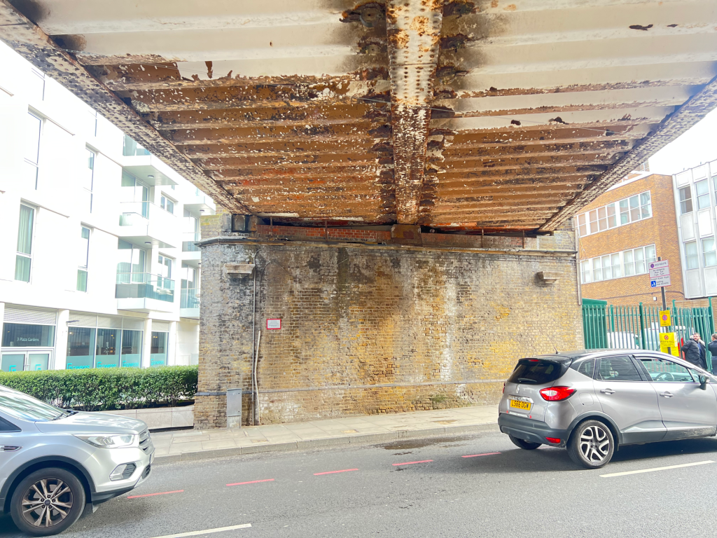 The underside of one of the two East Putney railway bridges - half-cleaned