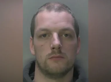 Mugshot of a man with short hair and stubble, looking straight ahead.