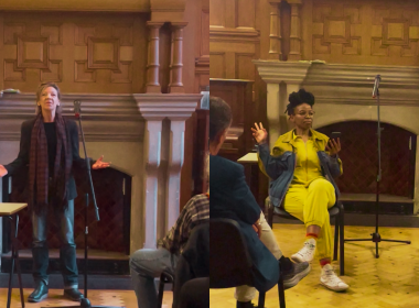 Panel discussion in a wood-paneled room; woman in a bright yellow suit gestures while another speaker stands at a microphone.