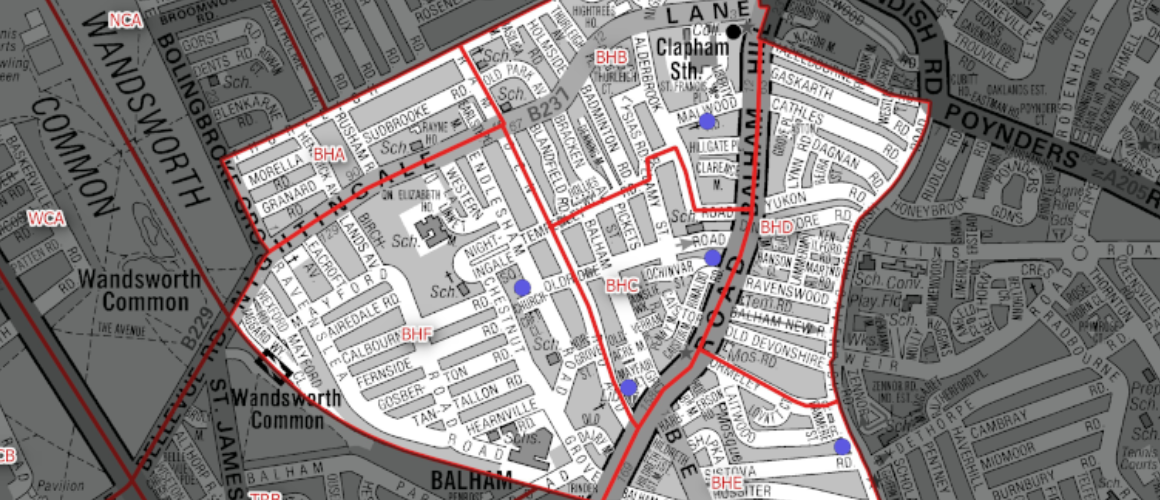 Grayscale map of a London area with red boundary polygons outlining a district and blue location markers, street names visible.