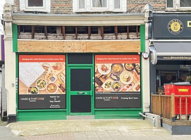 Row of shopfronts on a street: left Kerala Ayurveda sign, middle green-framed storefront with large food posters, right Dim Sum Kitchen signage.
