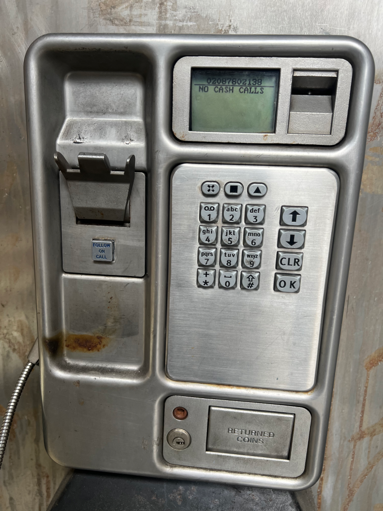Metal ATM panel with keypad and card slot; screen reads "NO CASH CALLS" behind a weathered, rust-streaked surface