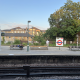 Platform at East Putney station with benches, a person sitting, and a large tree in the background