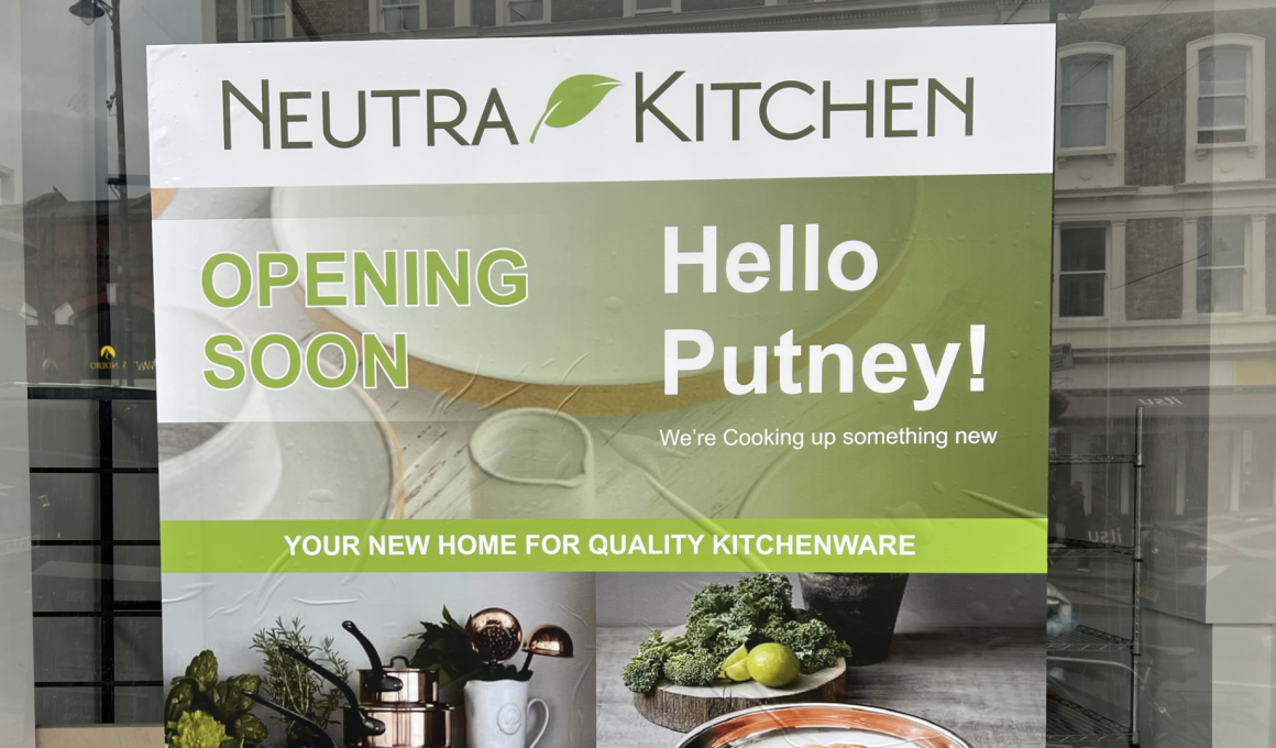 Sign for Neutra Kitchen announcing opening soon in Putney, with a green banner and 'Hello Putney!'