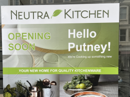 Sign for Neutra Kitchen announcing opening soon in Putney, with a green banner and 'Hello Putney!'