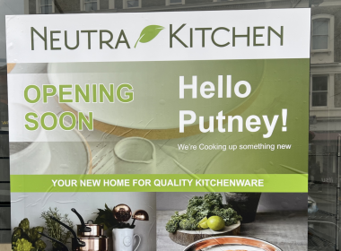Sign for Neutra Kitchen announcing opening soon in Putney, with a green banner and 'Hello Putney!'