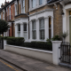Quiet Victorian terraced street in Putney at dusk with the front door of a house closed.