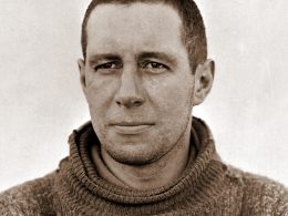 Black and white portrait of Lawrence Oates, head and shoulders, in a thick roll-neck jumper, looking straight at the camera.