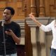 Adinoyi Okeji, left, and Nadia Larina, right, each performing at a microphone in the oak-panelled Putney Library Hall
