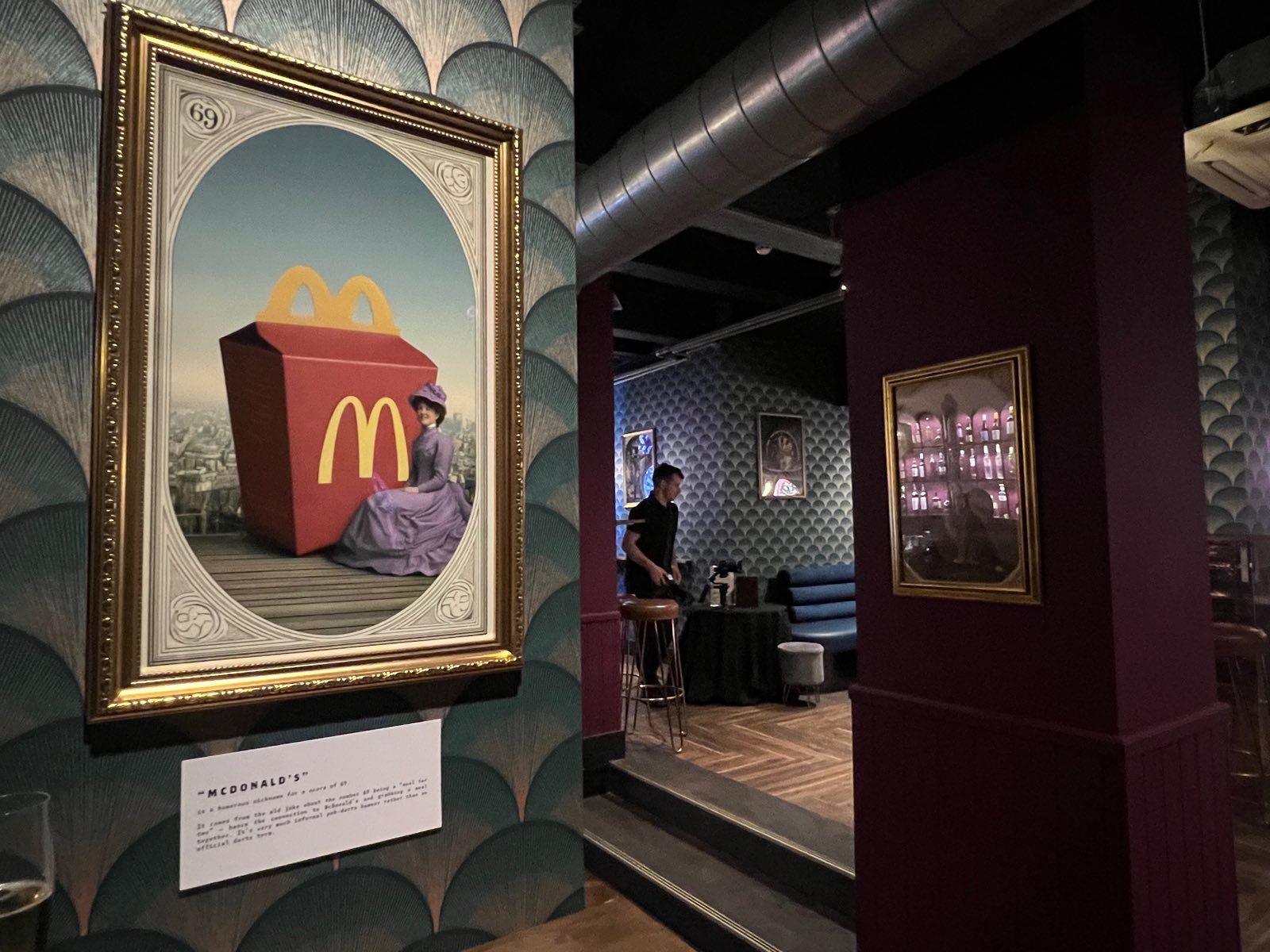 A framed painting of a Happy Meal box, captioned McDonald's