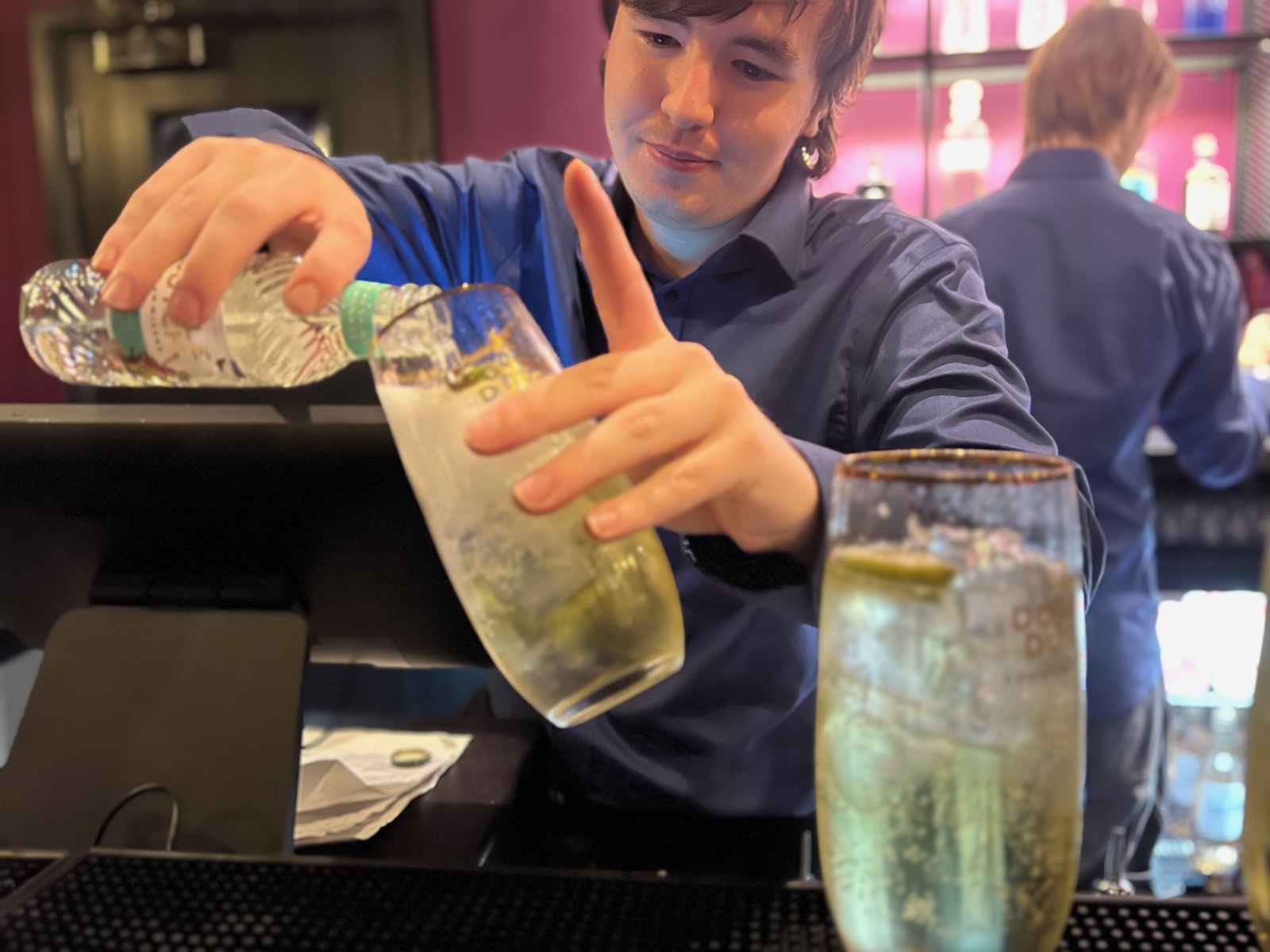 A barman pouring a gin and tonic
