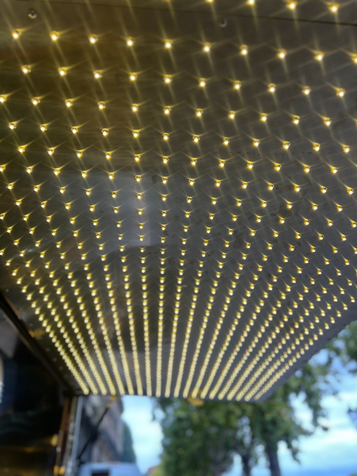 Underside of a trailer awning covered in rows of small warm-white lights
