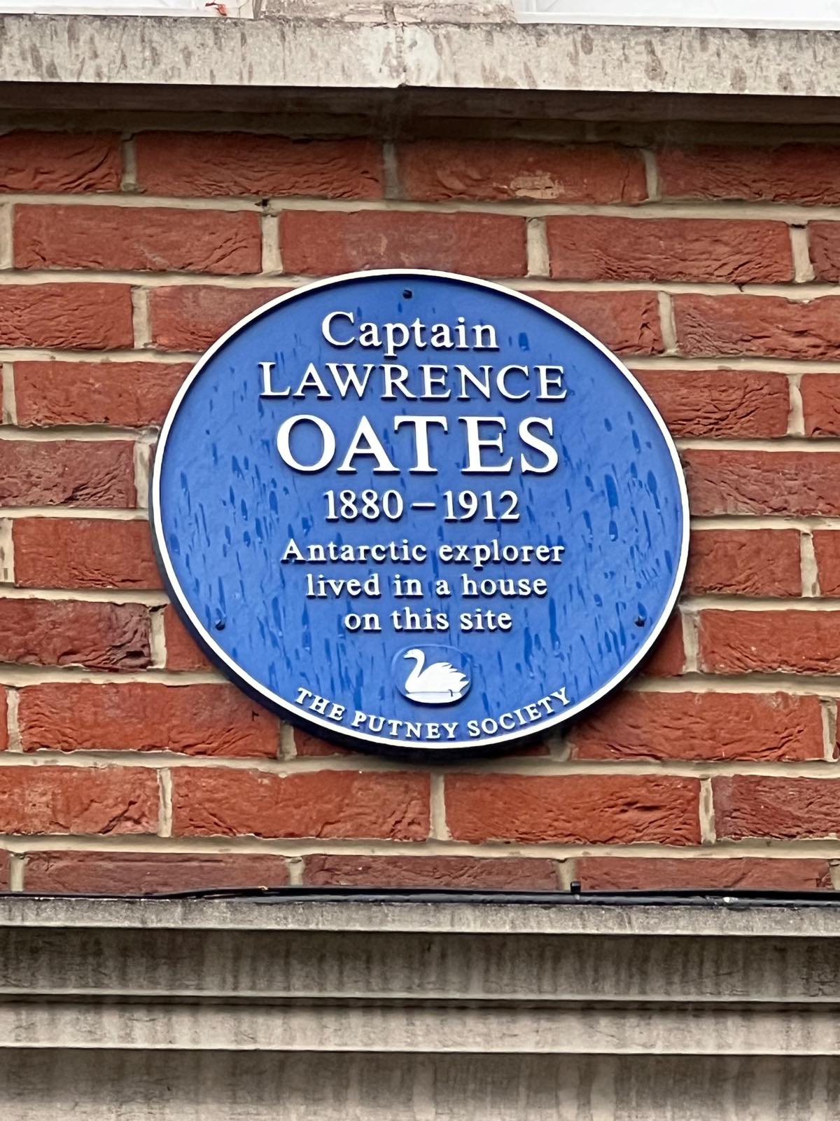 Blue plaque reading Captain Lawrence Oates 1880-1912 Antarctic explorer lived in a house on this site, The Putney Society