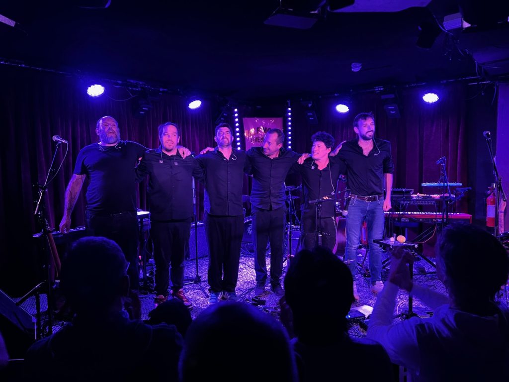 The six members of Paranohead stand arm in arm on the Half Moon stage to take a bow.
