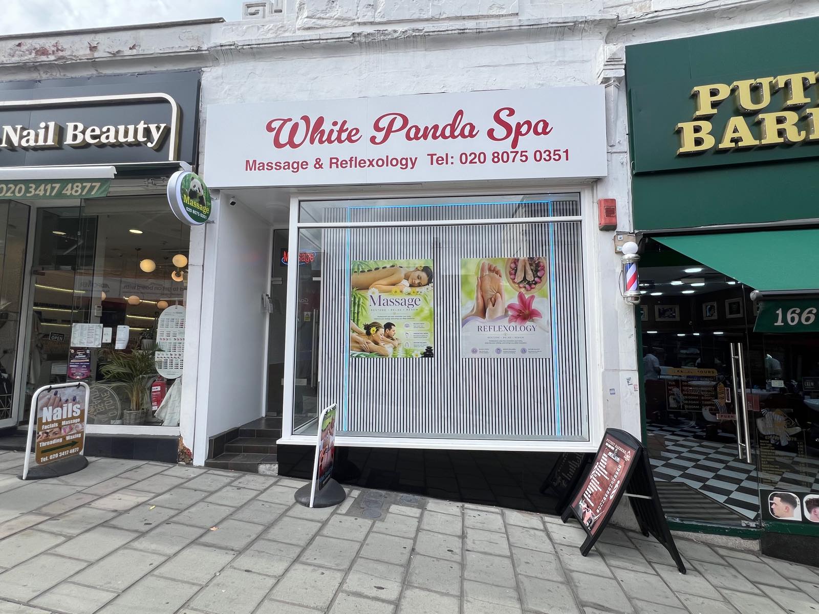 White Panda Spa shopfront with massage and reflexology posters in the window