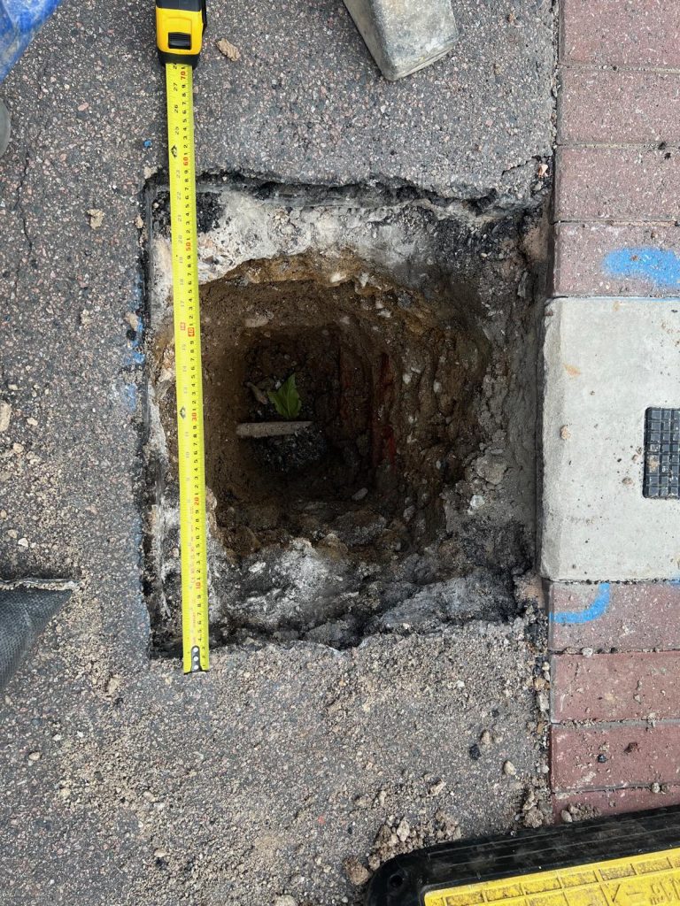 A tape measure laid across the Thames Water excavation in the pavement