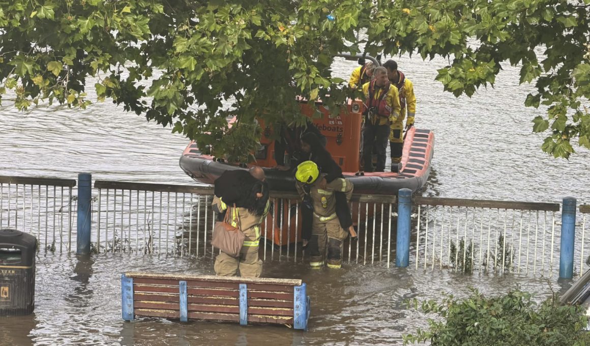 Women lifted onto a lifeboar afte the tide came in at Putney Embankment